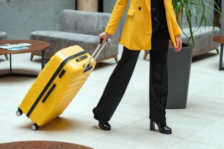 weoman pulling yellow suitcase