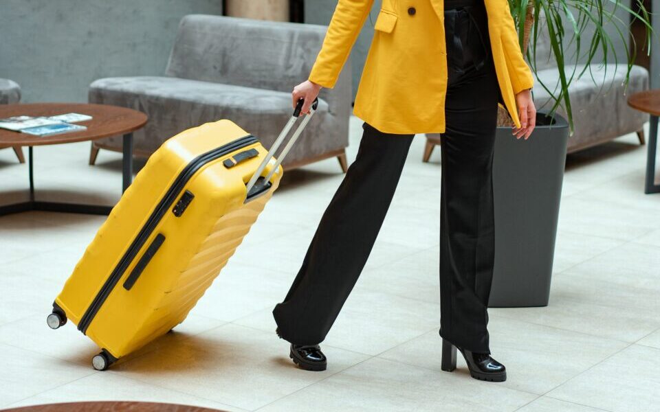 weoman pulling yellow suitcase